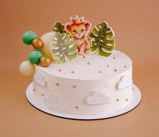 Colorful jungle-themed birthday cake with a lion decoration and tropical elements in a warm setting photo