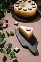 Layers of chocolate and cream dessert with decorative elements on a rustic surface photo