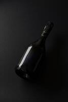 Black bottle of sparkling wine set against a dark background highlighting its elegant shape and design photo