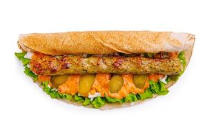 Delicious wrap with grilled kebab, fresh greens, and tangy sauce served in a casual dining setting during lunch hours photo