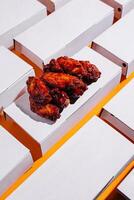 Delicious chicken wings served on orange background with multiple empty boxes surrounding them photo