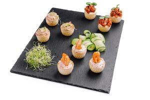 Creative gourmet appetizer display featuring mini pastry cups with various savory fillings and fresh garnishes photo