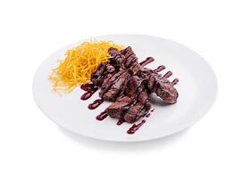 Juicy grilled steak with crispy potato strands and rich sauce on a white plate photo