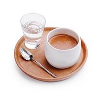 Hot beverage served with a glass of water on a wooden tray in a cozy setting photo