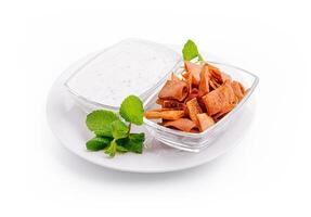 Traditional snack plate with crispy crackers and yogurt dip on a white background photo