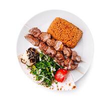 Tender skewers and flavorful side dishes create a delicious meal at a casual dining spot during lunchtime photo