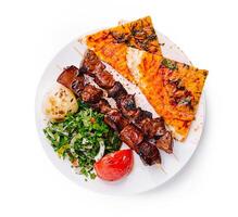 Delicious grilled skewers served with flatbread and fresh vegetables in a vibrant setting photo