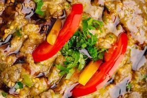 Deliciously garnished dish with vibrant peppers and herbs served on a shiny platter photo