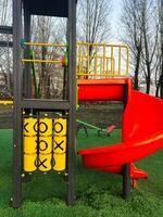Colorful childrens playground with a tic tac toe game and a red slide photo