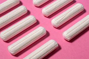 Softly arranged tampons on pink background product photography indoor setting close-up view for gentle appeal photo