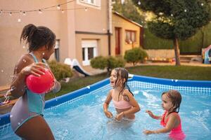 Children enjoying a playful afternoon in an inflatable pool photo
