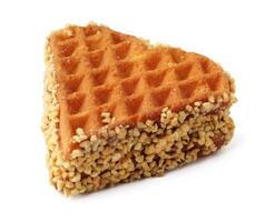 Triangular waffle coated with nuts resting on a white background, perfect for dessert lovers photo
