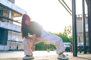 Dancer showcases dynamic moves in urban setting during golden hour photo
