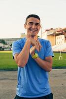 Smiling athlete enjoying sunlight at a sports field during training session in summer photo