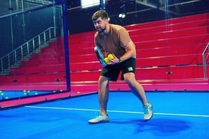 Player prepares to serve in a competitive padel match in an indoor arena during the afternoon photo