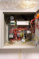 Electrical wiring inside a control box with various connected components in a modern building setting photo