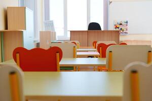 Bright and inviting classroom setup with colorful chairs and desks ready for students in a learning environment photo