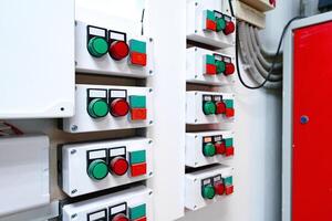 Control panel with multiple switches and indicators used for industrial automation in a factory setting photo
