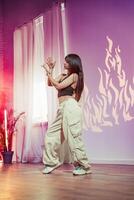 Dancer performs contemporary routine in studio with warm lighting and dynamic shadow patterns in the background photo