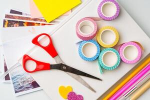 Crafting materials spread on a table for creative projects with scissors, washi tape, and colored paper photo