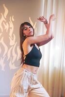 Young dancer showcases expressive movement in bright indoor space with abstract shadow patterns photo