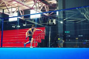 Intense indoor squash player showcases skills during a competitive match in a modern sports facility photo