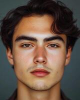 A young man stares directly at the camera with confidence and a calm demeanor, showcasing his unique features photo
