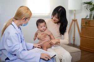 Pediatrician examining baby with parent during a health consultation photo