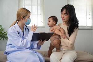 Doctor discussing health with parent and baby during a pediatric consultation photo