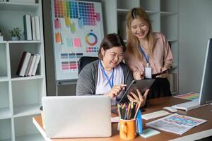 Dynamic graphic design team collaborating on projects with digital devices in a colorful studio photo