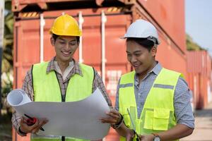Logistics engineer and colleague reviewing blueprints in a construction setting. photo