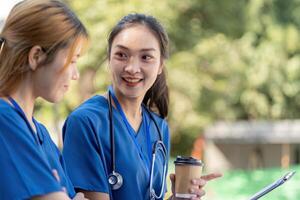 Doctors enjoying a break, conversing with coffee and a clipboard. photo