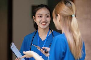 Doctors conversing during a break, sharing smiles and a clipboard. photo