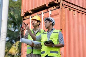 Engineers discussing logistics and project management at a shipping container site photo