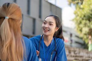 Doctors smiling and conversing during a break in the sunshine. photo