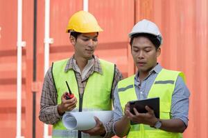 Logistics engineer reviewing plans with a colleague using a tablet. photo