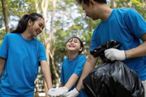 Happy family volunteers enjoying their time while collecting garbage in a park, showcasing teamwork and environmental commitment. photo