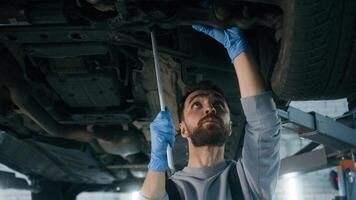 Caucasian man guy technician repairman auto mechanic repair truck in car service station male working underneath lifting vehicle in garage transport maintenance fixing automobile with mechanical tool photo