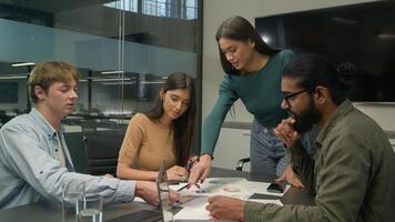 Team leader coworkers planning work analyzing corporate documents reviewing statistics learn data charts graphs group diverse businessmen businesswomen discuss business paperwork in office boardroom photo