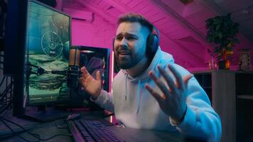 Frustrated Caucasian blogger male guy modern cyber sport host influencer addict man touch keyboard streamer lose game vlogger playing gaming computer at home upset gamer defeat difficulty neon stream photo