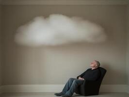 Senior man relaxing and daydreaming under a cloud indoors photo