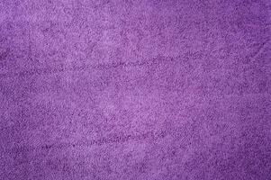 Purple suede as a background. Macro photo of the texture of natural dyed purple suede leather
