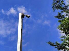 a camera on a pole with a blue sky in the background photo