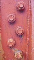 a close up of a rusty metal structure with four bolts photo