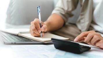A man is using a calculator to calculate his income tax to fill out his annual income tax return photo