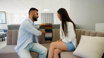Couple Discussing Sofa Fabric Choices in Furniture Store video