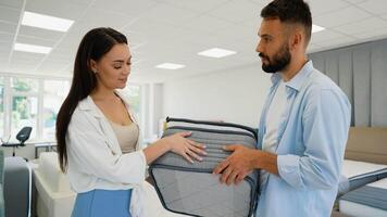 A couple inspects the quality and features of a mattress in a furniture store video