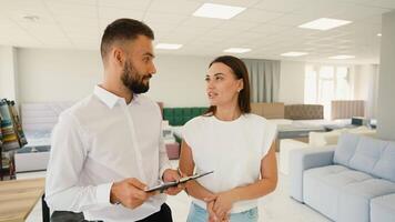 Furniture Consultant Assists Customer Choosing Sofa in Store video