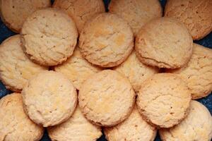 A pile of round cookies on a dark background. Top view. photo