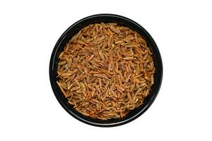 Cumin seeds in a black bowl isolated on a white background. photo